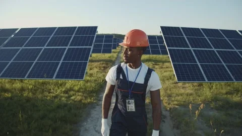 Afro-american young worker walking on solar panel field. Ecological installation Stock Footage 135281657