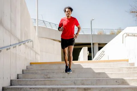 Afro athletic man doing exercise outdoors. Stock Photos