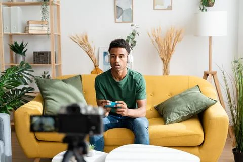 Afro boy playing video games while filming for his video blog Stock Photos