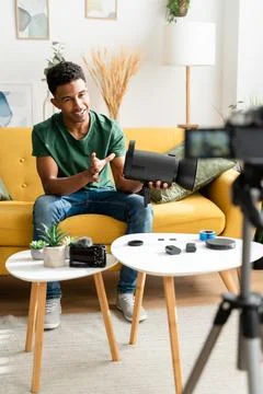 Afro guy showing off a studio flash while filming for his video blog Stock Photos