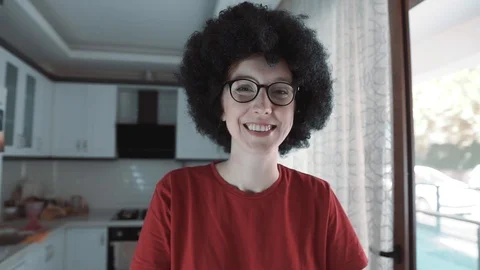 Afro haired, curly head white woman is waving hand when she's smiling. Video stock 108622738