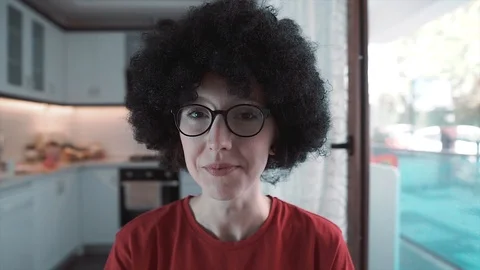 Afro haired, curly head white woman is waving hand when she's smiling. Stock Footage 109067070
