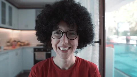 Afro haired, curly head white woman is waving hand when she's smiling. Stock Footage 109067175
