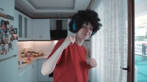 Afro haired ethnic young girl is listening music with headphones and dancing Stock Footage 109068053