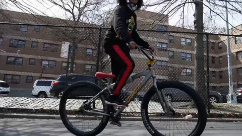 Afro Kid Doing BMX Bunny Hop Public Park Stock Footage 128085664