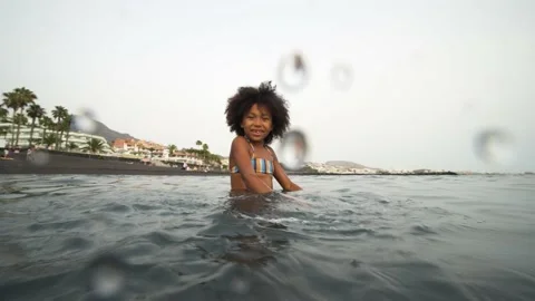 Afro kid splashing water on camera Stock Footage 137440634