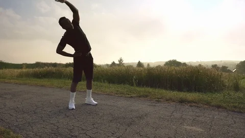 Afro male runner doing stretching exercises before workout Stock Footage 121272528