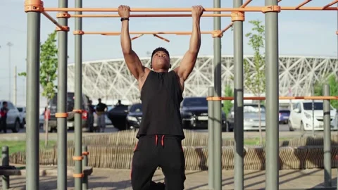 Afro man doing pull ups on horizontal workout outdoors Stock Footage 143500914