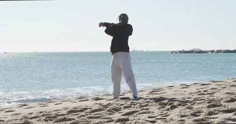 Afro man with dreadlocks doing stretching on the beach Stock Footage 146951713