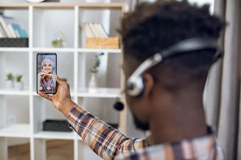 Afro man in headset using smartphone for video conversation 스톡 사진