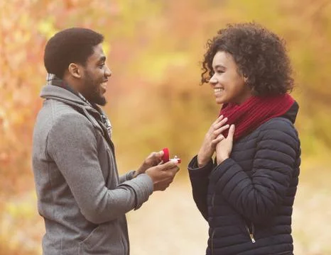 Afro man making propose to his girlfriend Stock Photos