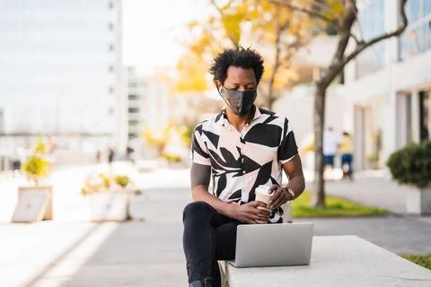 Afro man using his laptop outdoors. Stock Photos