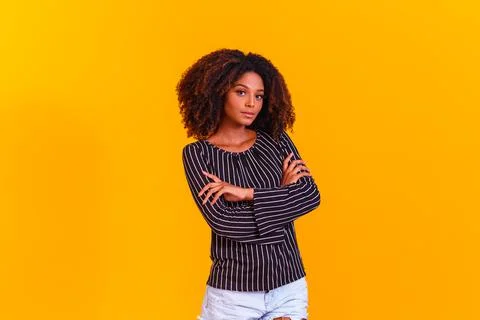 Afro woman cross arms in yellow background Stock Photos