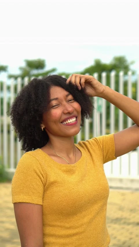Afro woman looking at camera while posing in park Stock Footage 225711163