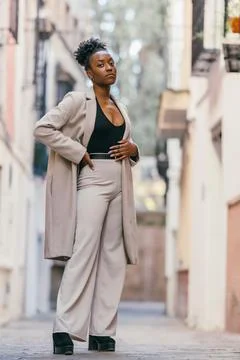Afro woman posing while looking at the camera with a cocky expression outdoors Stock Photos