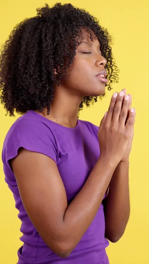 Afro woman praying while looking up joining hands Stock Footage 239909777