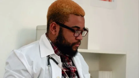 Afroamerican doctor working with documents in his office Stock-Footage 71991785
