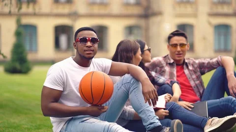 Afroamerican student looking at the camera while holding a basketball ball and Stock Footage 126283241