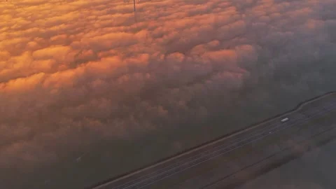 Afsluitdijk road and offshore wind turbines at sunrise above calm Dutch waters. Stock Footage 321891574