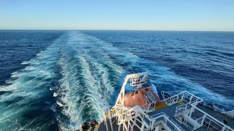 AFT SIDE VIEW OF A CARGO SHIP WHILE MOVING IN THE SEA. Stock Photos