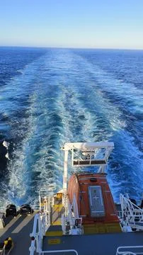 AFT SIDE VIEW OF A CARGO SHIP WHILE MOVING IN THE SEA. Stock Photos