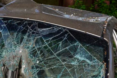 After the car crash, windshield fall on the road surface. Stock Photos