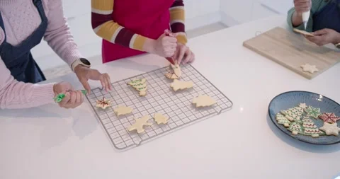 After center placing cookie, three women are piping with bags, filling plate on Stock Footage 345270751