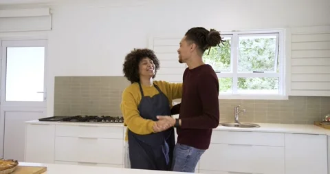 After clasping hands diverse couple dancing in kitchen around island passing 스톡 동영상 317788557