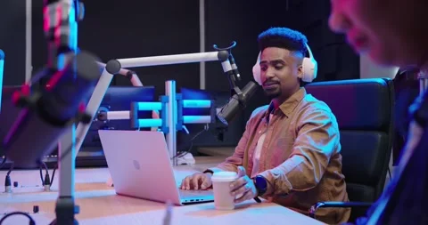 After co-host prompt Diverse co-hosts in studio host adjusting mic speaking Stock-Footage 342608412