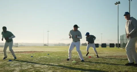 After coach clap diverse baseball team doing footwork drill on outfield using Stock Footage 336714993