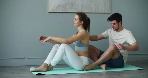 After doing yoga at home on the mat, the man gives the woman a back massage. Stock Footage 148133082