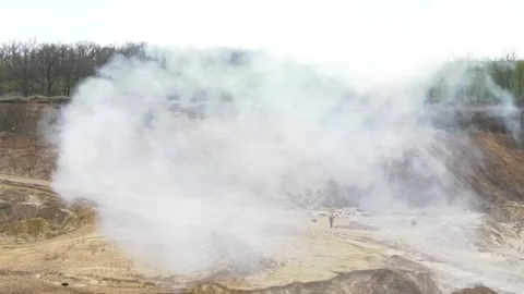 After the explosion, thick white smoke rises on the sandy landfill. Stock Footage 307167174