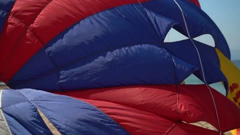 After a flight, a parasail eases to the ground in preparation for the next Stock Footage 166078185