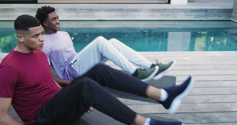 After flutter kicks on mats, diverse male friends high-fiving, chatting and Stock Footage 314030708