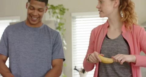 After fruit prep diverse friends slicing cucumber and peeling banana at kitchen Stock Footage 338061884