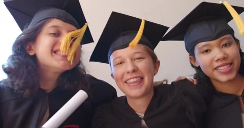After grad under canopy diverse female grads gowned leaning to low cam with Stock Footage 340655956