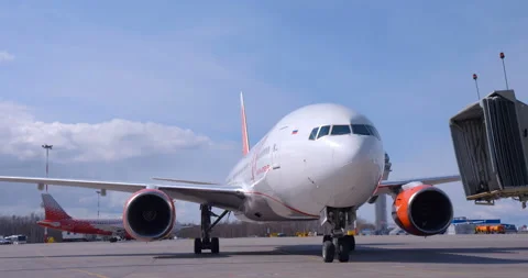 After landing, the plane approaches the telescopic passage for disembarking Stock Footage 119577807
