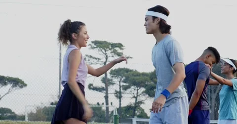 After lining near net, Diverse tennis teammates doing stretches on outdoor Stock Footage 337536904