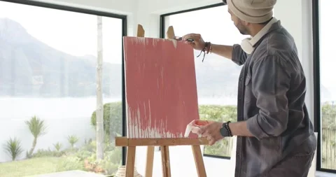 After loading brush with red paint artist is painting horizontal strokes for red Stock Footage 341320242