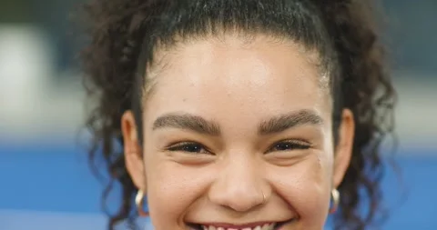 After match, female player shifting sweat-slicked face into broad laughter in Stock Footage 337932688