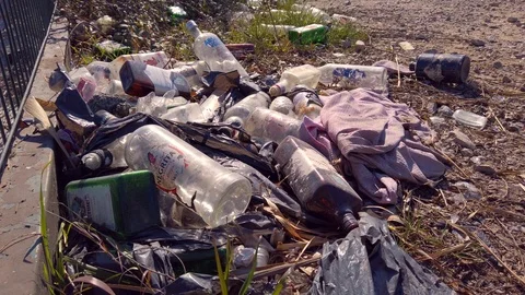 After party pollution: garbage and trash bottles abandoned at the field Stock Footage 125913219