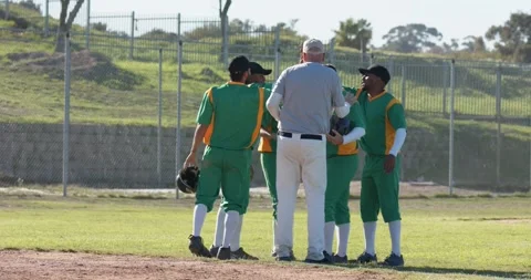 After passing senior umpire five diverse male baseball players clapping gloves Stock Footage 344644082
