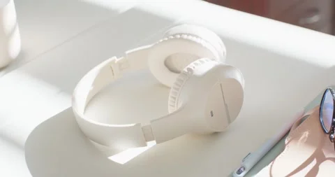 After pause hand is entering, adjusting and lifting headphones off sunlit Видео 344404294
