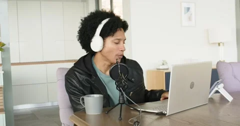 After placing laptop and microphone man putting on headphones at home dining Stock Footage 337537226