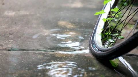 After rain, flooding on the ground with old bicycle wheels Stock Footage 63623639