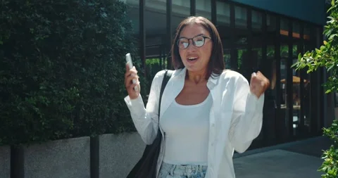 After reading positive message on phone woman face beams with happiness emotions Stock Footage 312504993