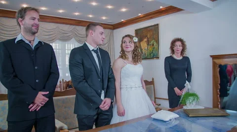 After the registrar stops reading the bride and groom are putting on the rings Stock Footage 47191886