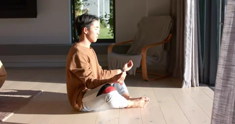 After settling cross-legged, Asian man adopting mudra for calm near sliding Video stock 314043133