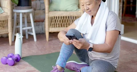 After short exercise, Asian senior woman resting on porch mat with towel, Stock Footage 341938596