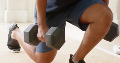 After step, African American man in shorts doing weighted lunges holding Stock Footage 341091841